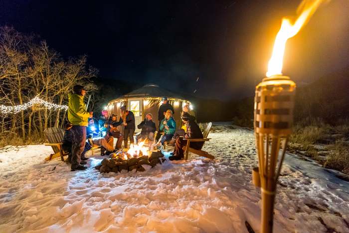 Wandelend op sneeuwschoenen loop je door het bos naar de sfeervolle yourt voor een 4-gangendiner